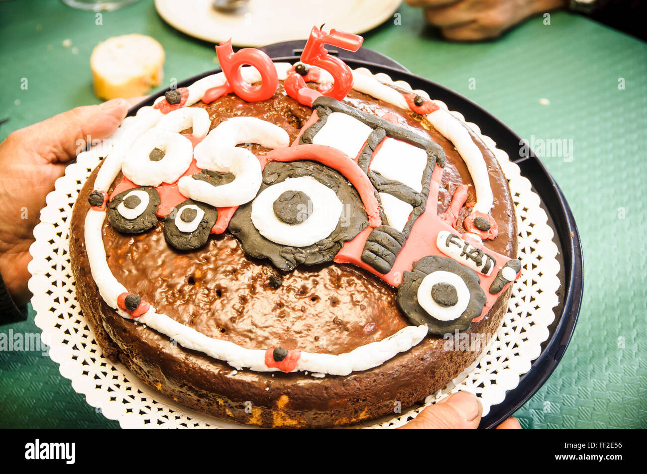 65 birthday cake with candles and chocolate tractor Stock Photo