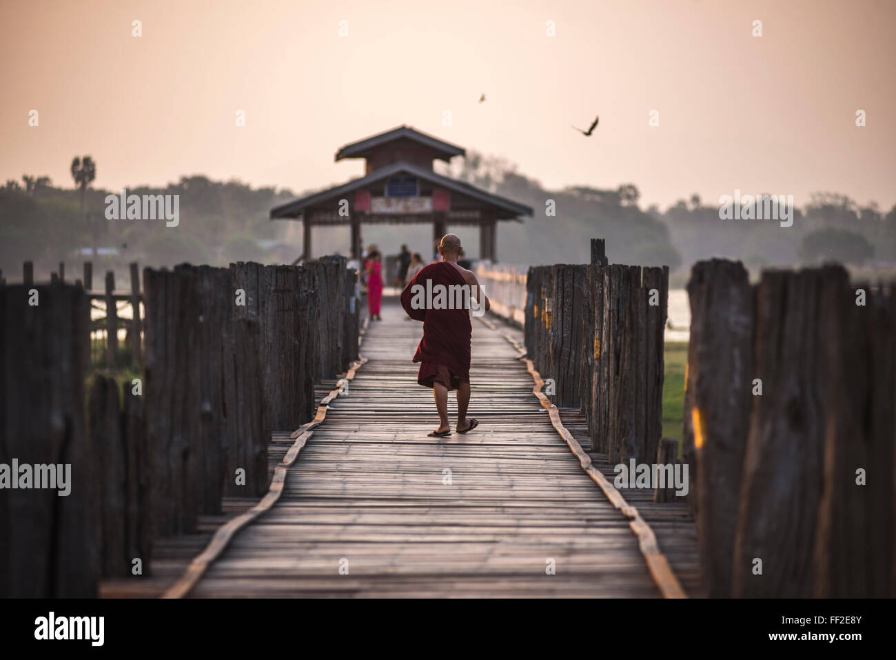 Buddhist Monk on U Bein Teak Bridge at sunrise, MandaRMay, MandaRMay Region, Myanmar (Burma), Asia Stock Photo