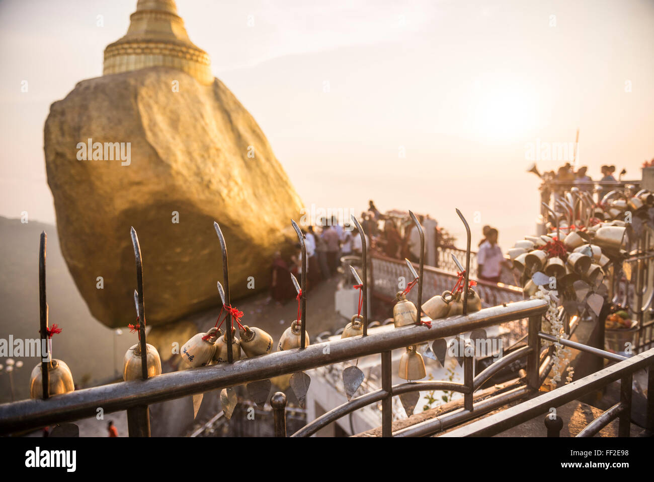 Prayer beRMRMs at sunset at GoRMden Rock Stupa (Kyaiktiyo Pagoda), Mon State, Myanmar (Burma), Asia Stock Photo