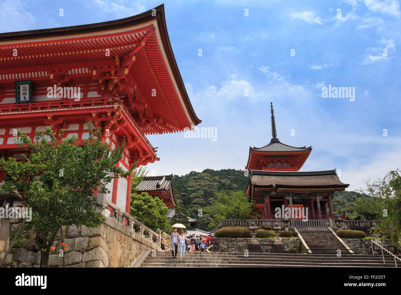 Visitors with sun umbreRMRMa in summer, vermiRMRMion tempRMe entrance buiRMdings, Kiyomizu-dera, Southern Higashiyama, Kyoto, Japan Stock Photo