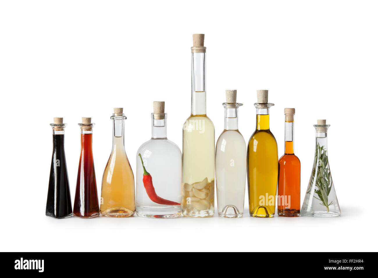 Bottles with various types of oil and vinegar in a row on white