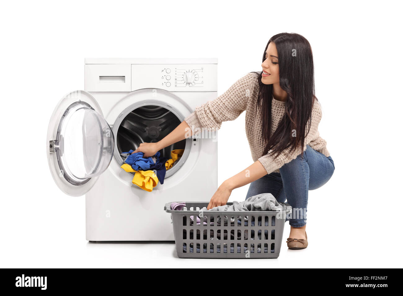Young woman emptying a washing machine isolated on white background Stock Photo