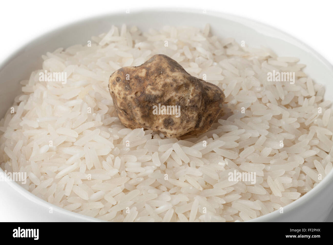 Tuffle Brown Rice Cup of raw rice with fresh white truffle on white background Stock ...