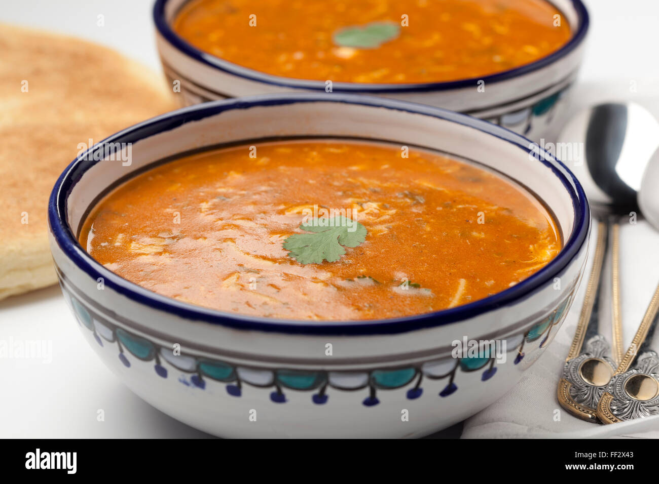 Traditional Moroccan harira soup with coriander and bread Stock Photo