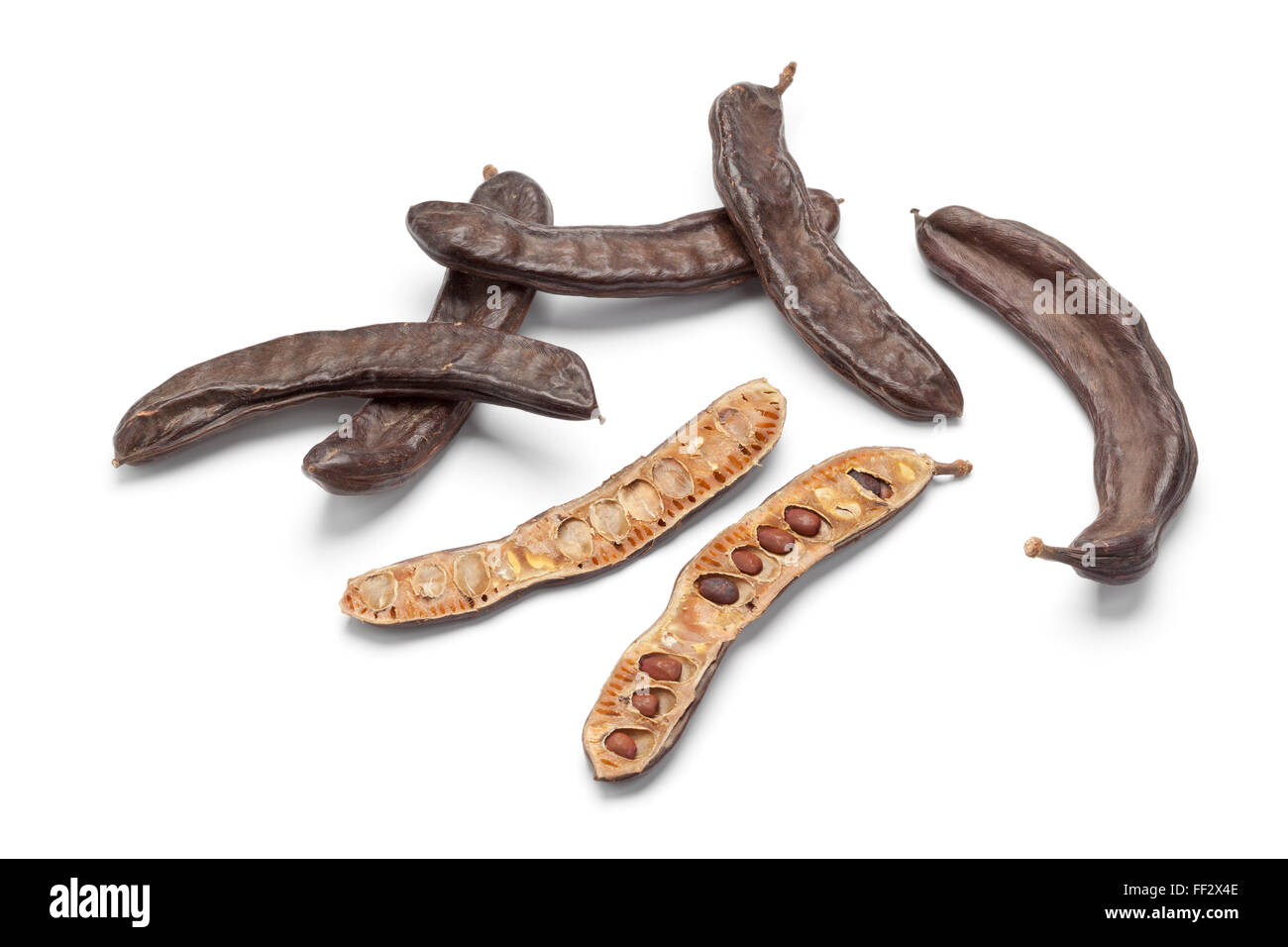Whole and half Carob pods on white background Stock Photo