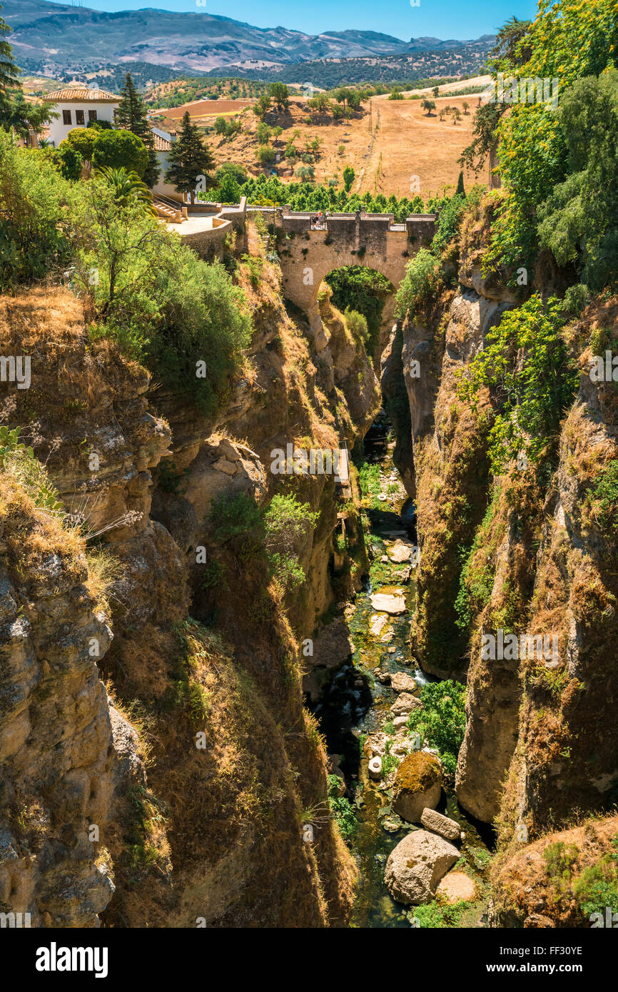 The Puente Viejo (Old Bridge) is oldest and smallest of three bridges that span the 120-metre deep chasm that carries Guadalevin Stock Photo