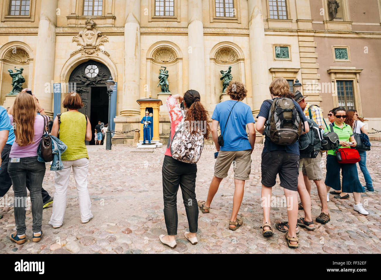 STOCKHOLM, SWEDEN - JULY 30, 2014: Tourists visit and photograph the guard of honor at the Royal palace in Gamla Stan, where kin Stock Photo