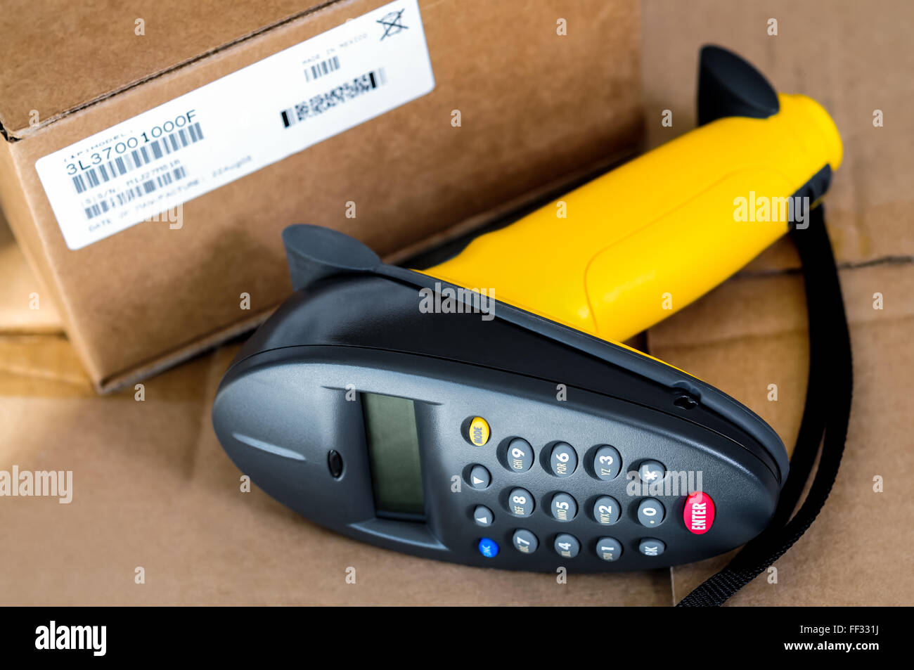 Barcode scanner reader laying next to a box with a UPC bar code label. Stock Photo