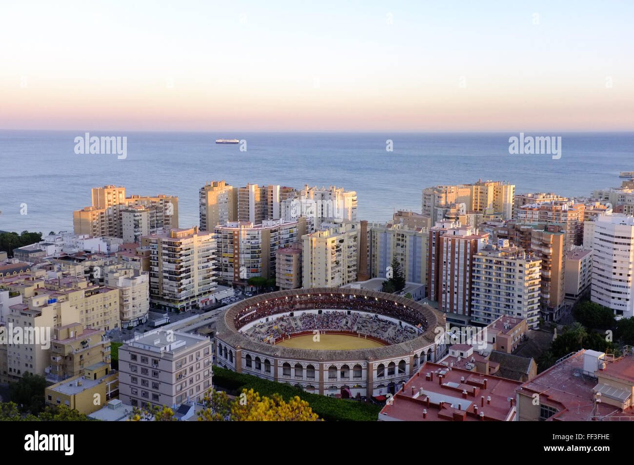 La Malagueta bullring in Malaga, Spain as seen from the hills above the town. A bullfight is taking place. Stock Photo