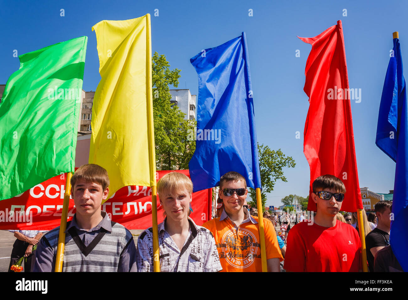 GOMEL, BELARUS - MAY 9, 2013: Unidentified youth from patriotic party BRSM holds flags on the celebration of Victory Day. Stock Photo