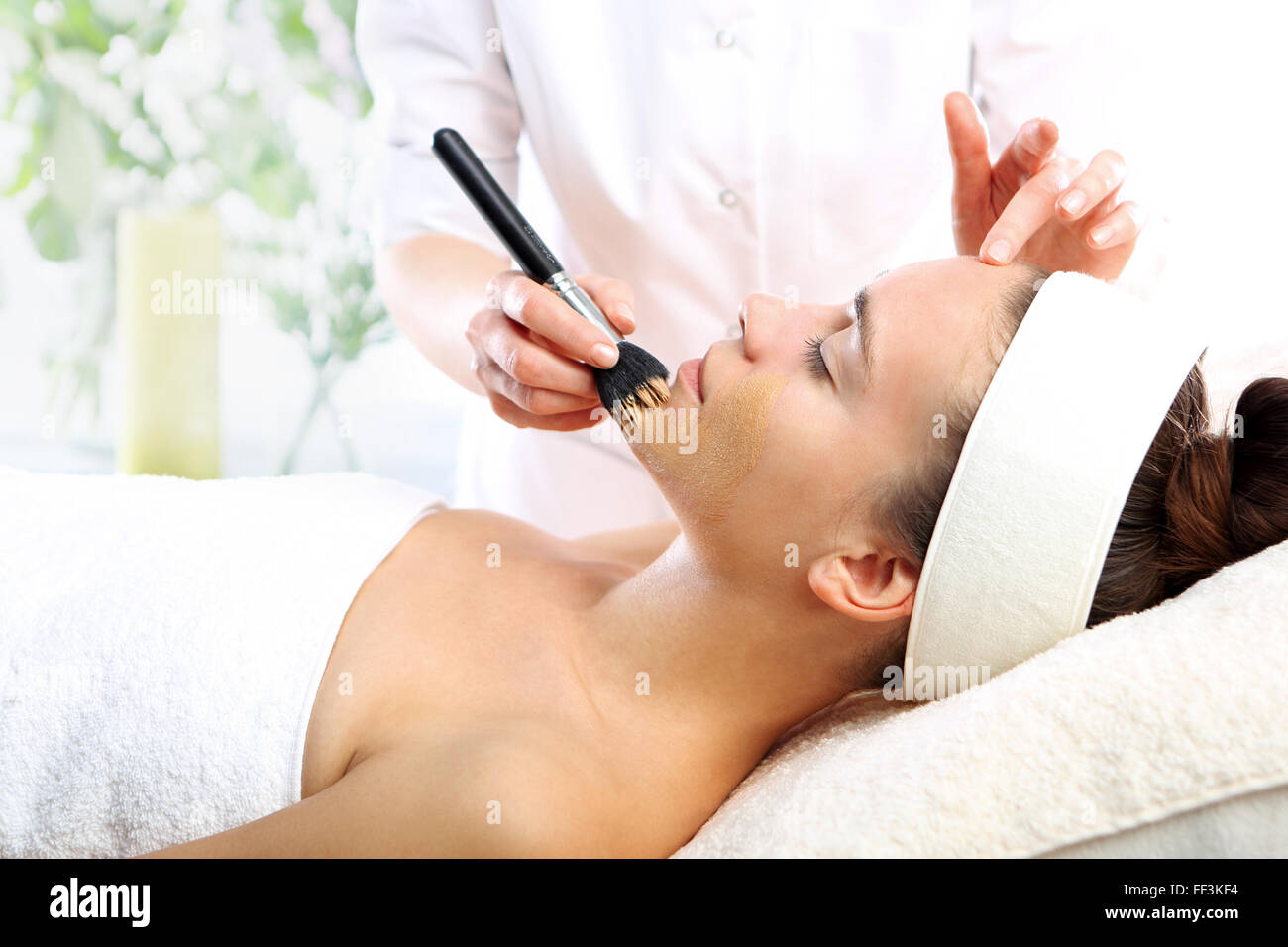 Makeup artist applied foundation. Woman in a beauty salon, makeup artist applied primer for face Stock Photo