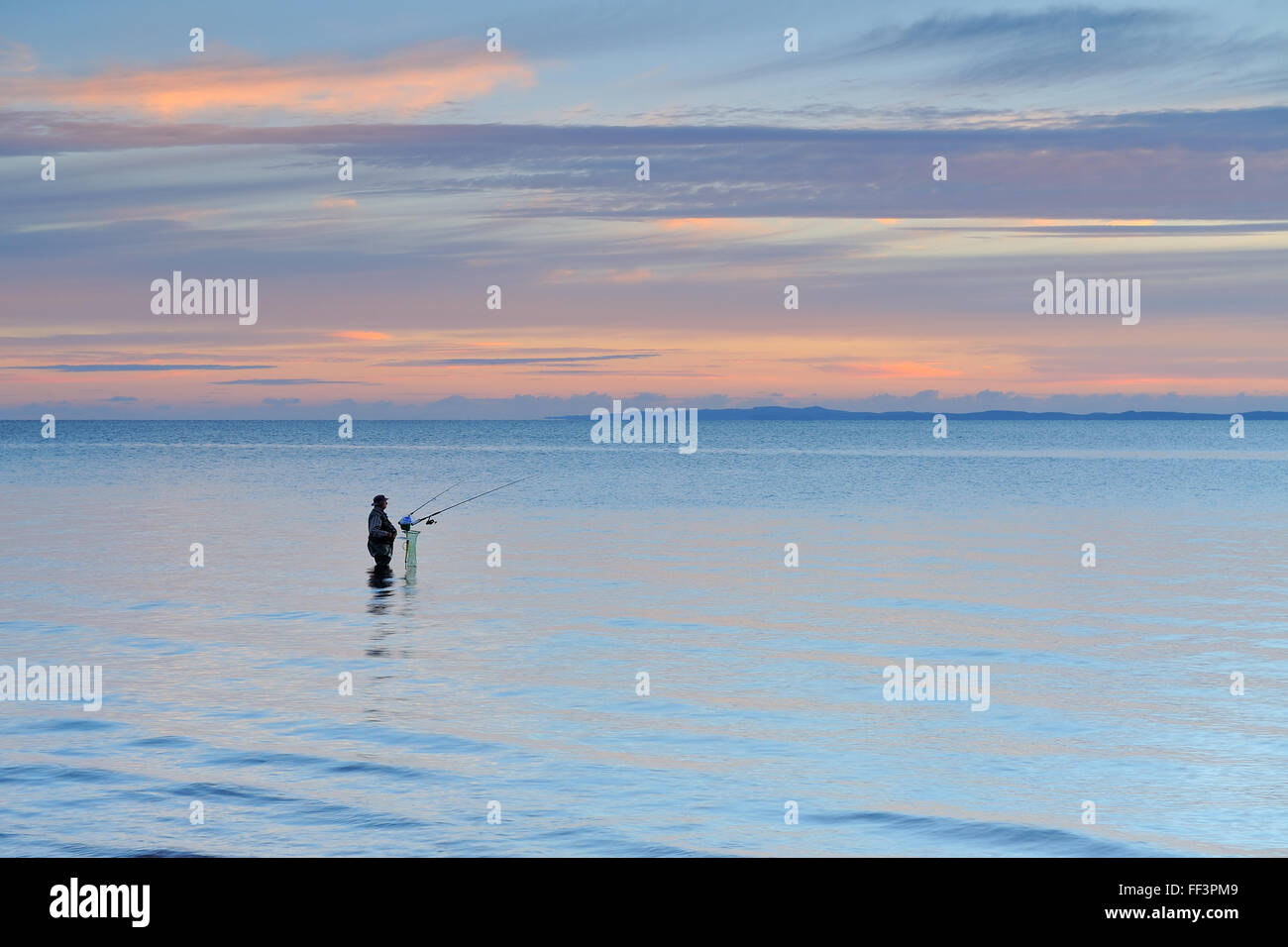 Fisherman in a tranquil ocean Stock Photo