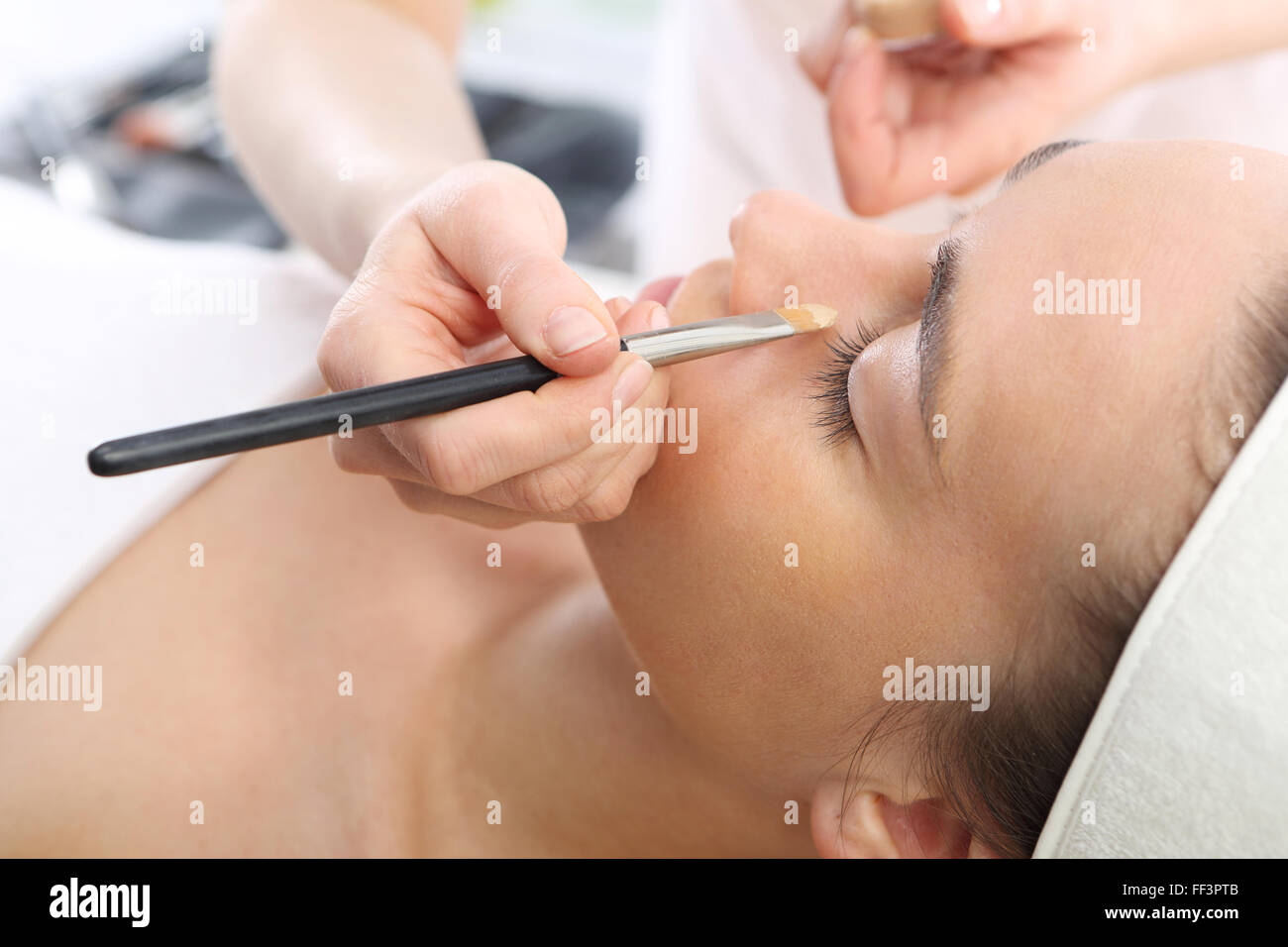 Makeup artist applied foundation. Woman in a beauty salon, makeup artist applied primer for face Stock Photo