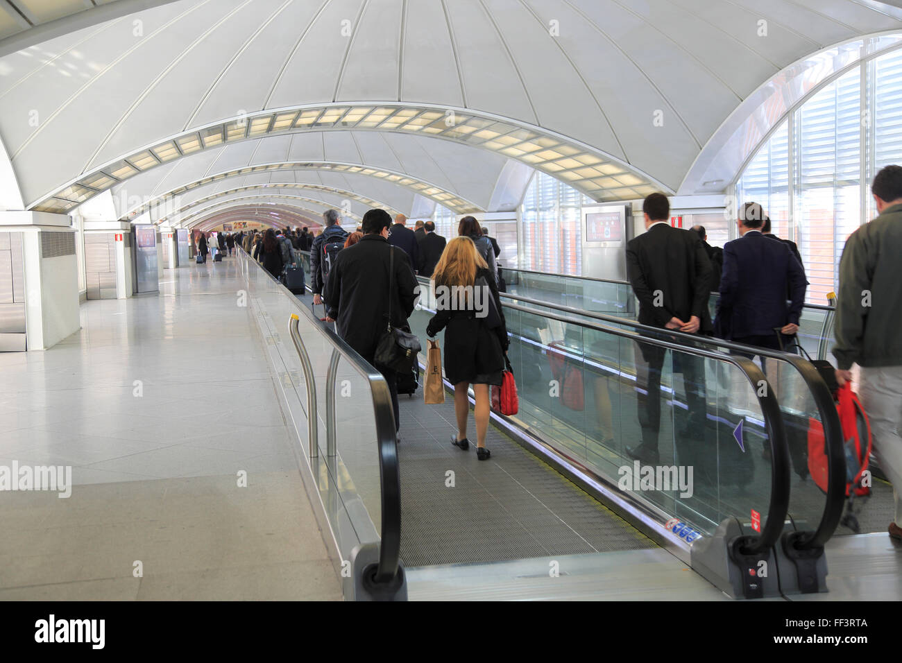 Passengers pulling luggage bags along a bright corridor, Atocha railway station, Madrid, Spain Stock Photo