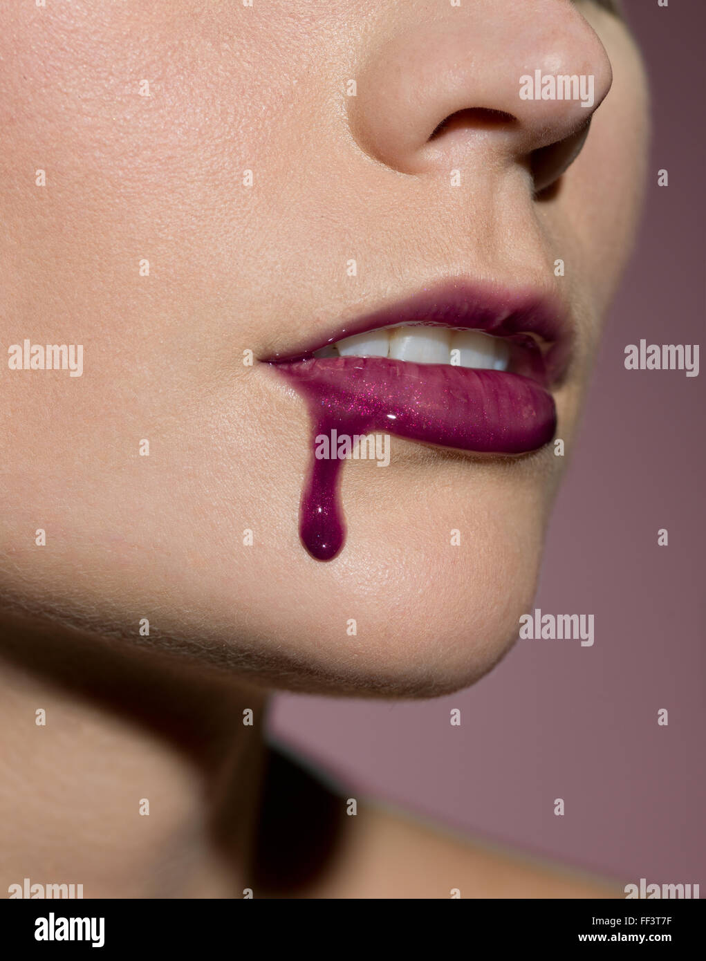 Lip gloss dripping from woman's lip Stock Photo