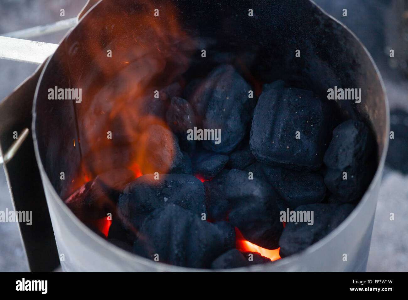 Charcoal burning in metal container Stock Photo Alamy