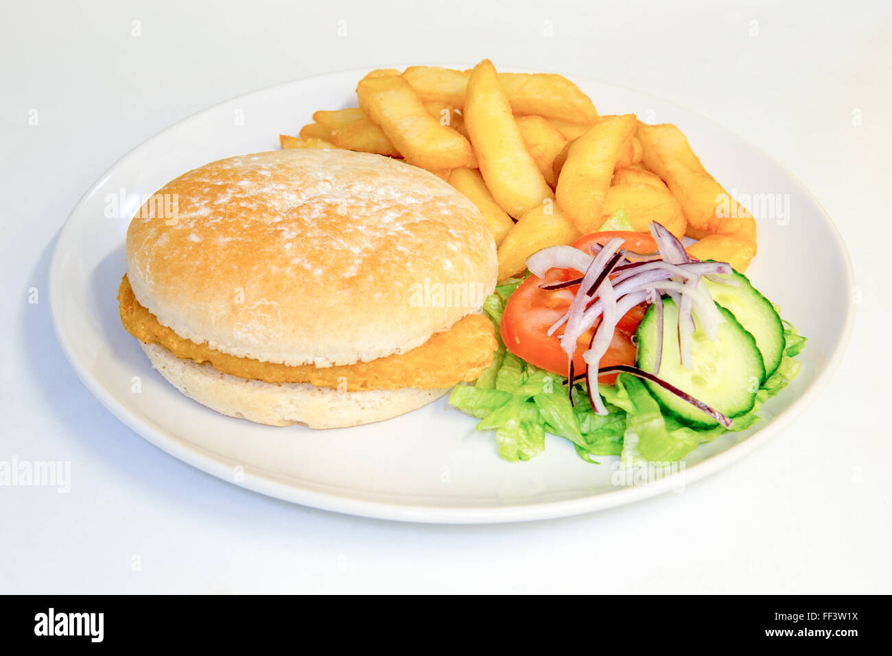 Breaded chicken burger in a bun meal with chips and salad Stock Photo