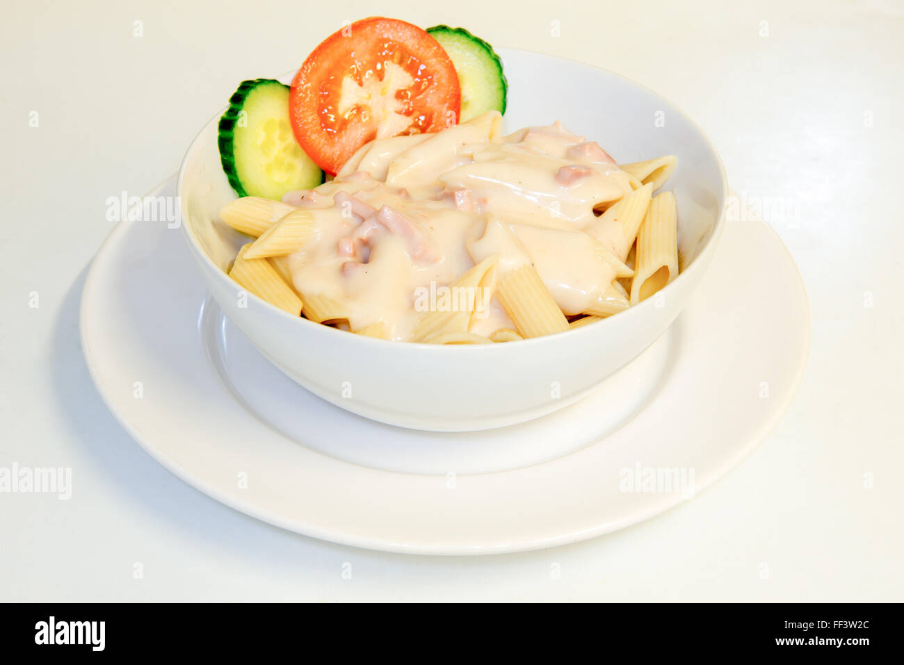 carbonara sauce and pasta in a bowl with small salad Stock Photo