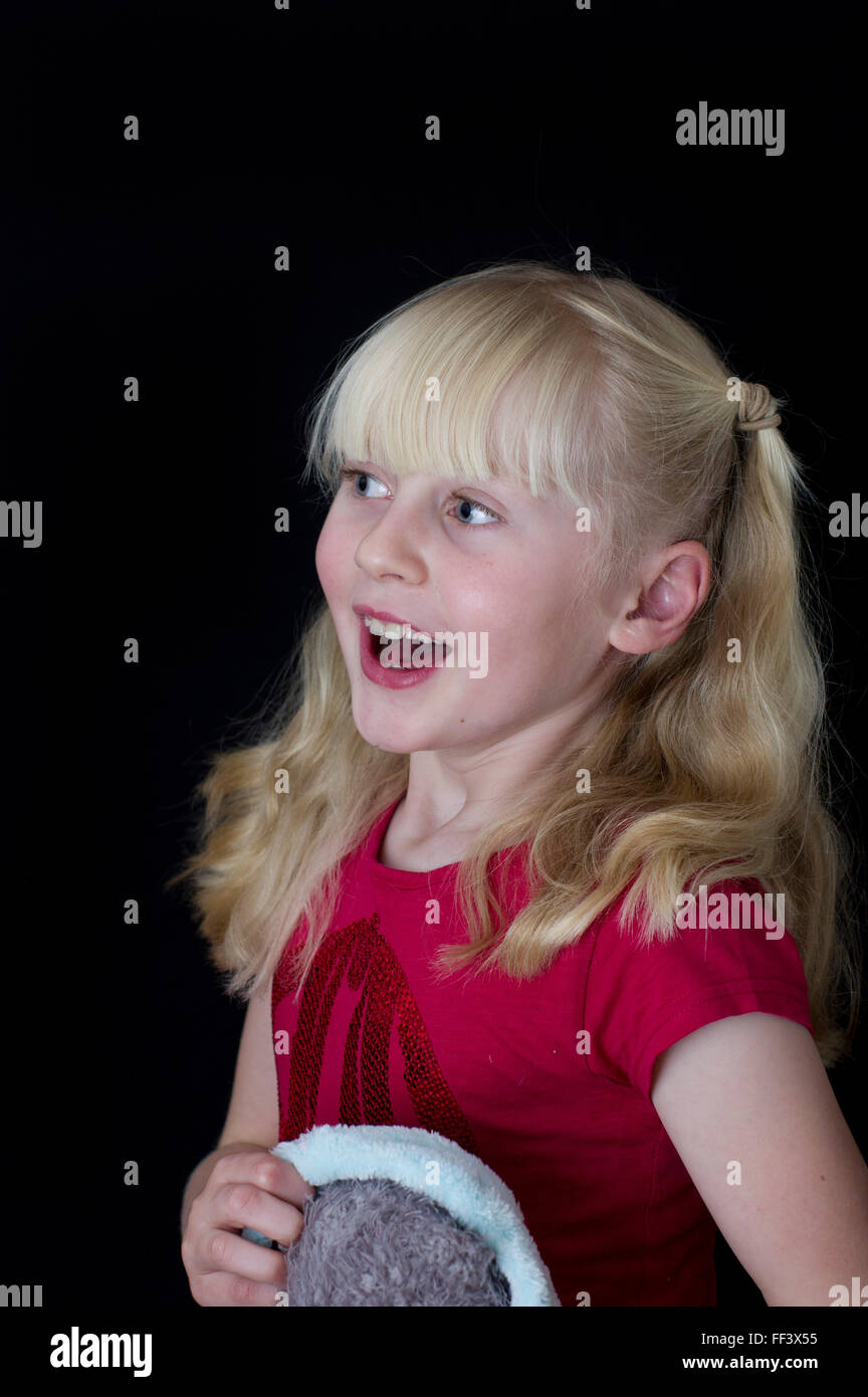 Studio portrait of a young blond girl with bunches against a white background. Stock Photo