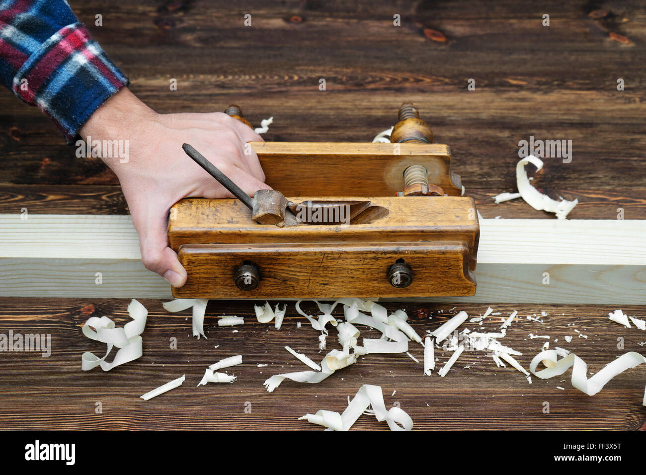 Hands of a carpenter planed wood Stock Photo