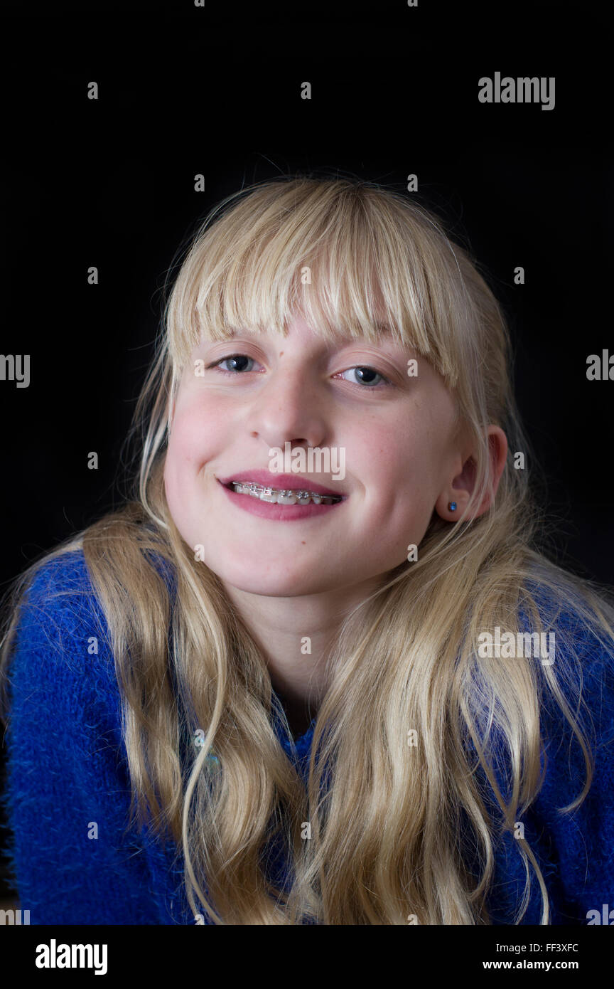 Studio portrait of a young, blond girl against a white background. Stock Photo