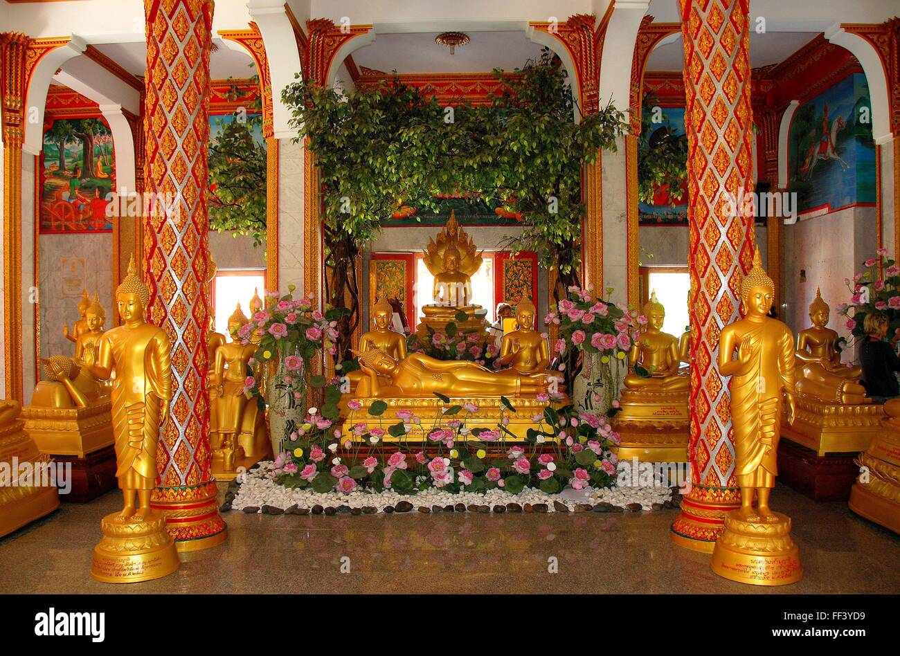 Phuket, Thailand:  Gilded standing, seated, and reclining Buddha figures inside the Viharn hall at Wat Chalong * Stock Photo