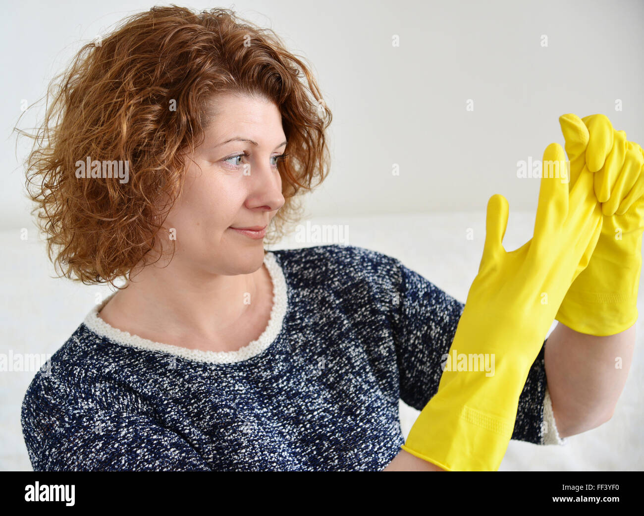 Woman takes off rubber gloves after cleaning Stock Photo Alamy