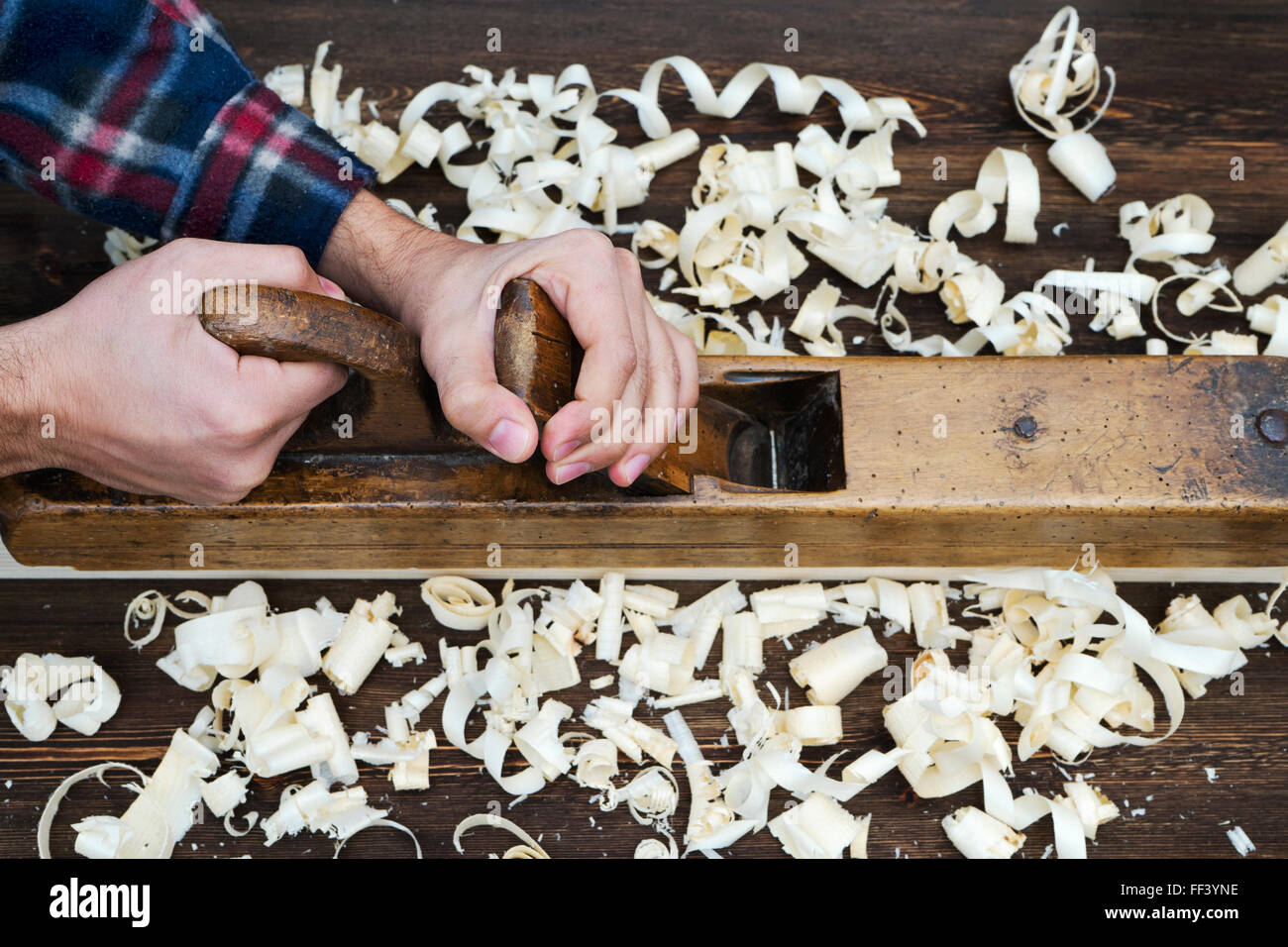 Hands of a carpenter planed wood Stock Photo