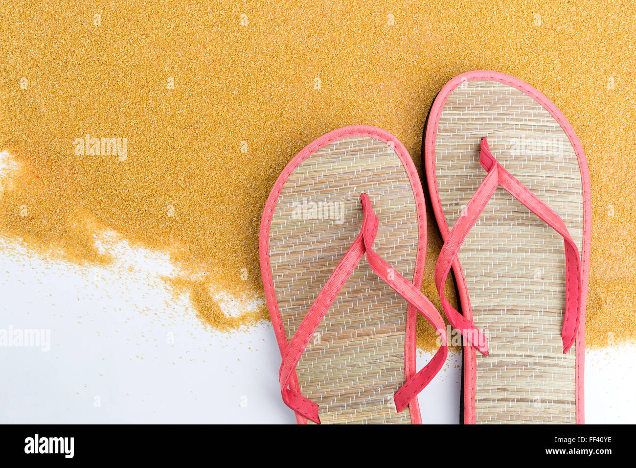 Pink flip flips on sand for background Stock Photo - Alamy