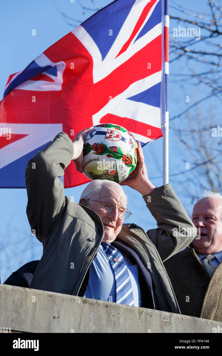 Ashbourne, UK. 10th February, 2016. 100-year old starts Ashbourne Shrovetide football. D-Day veteran Bill Milward celebrates his 100th birthday by ‘turning up’ the ball to start off the second day of play for Ashbourne’s Royal Shrovetide Football. The game, played through the streets of Ashbourne, Derbyshire, has been staged almost every year since at least the 17th Century. It is played on Shrove Tuesday and Ash Wednesday, starting at 14:00 each day and ending at 22:00. Credit:  Robin Weaver/Alamy Live News Stock Photo