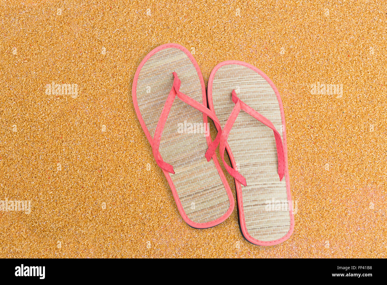 Pink flip flips on sand for background Stock Photo - Alamy