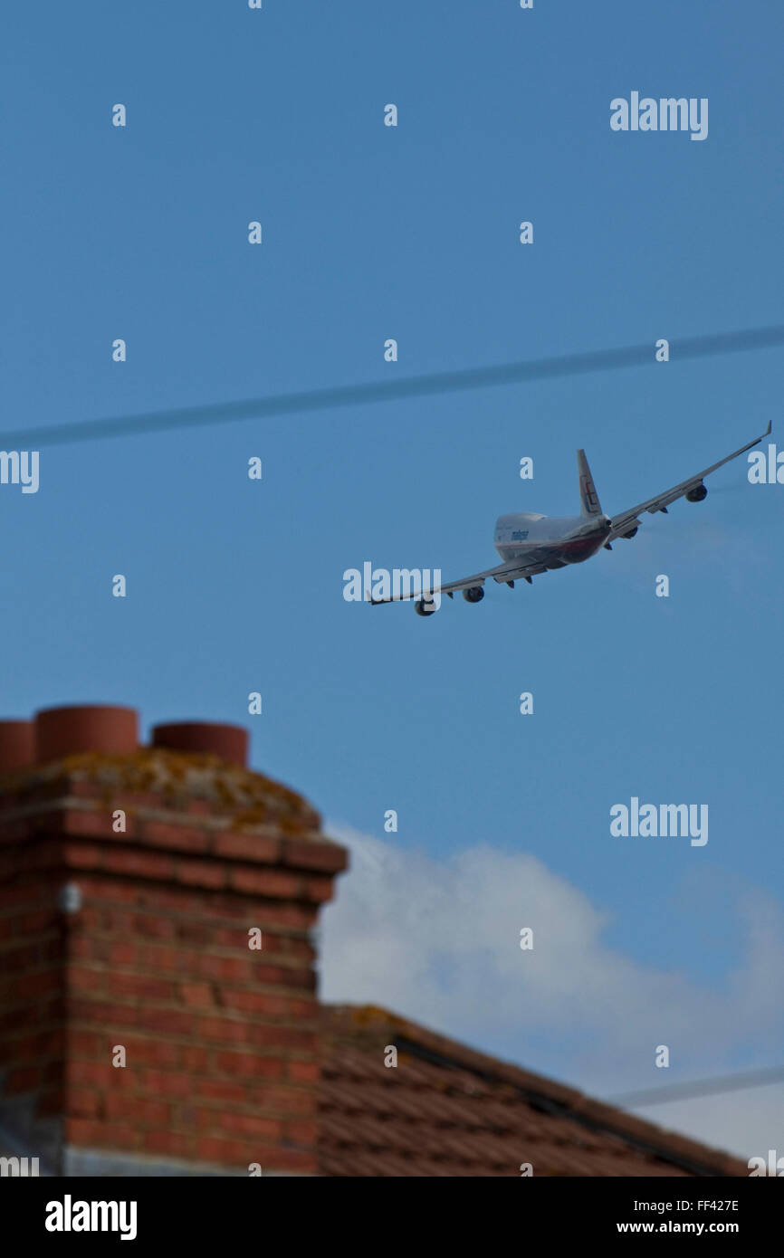 A Malaysian airways Boeing 747 soaring over local houses in Hatton near London Heathrow airport. Stock Photo