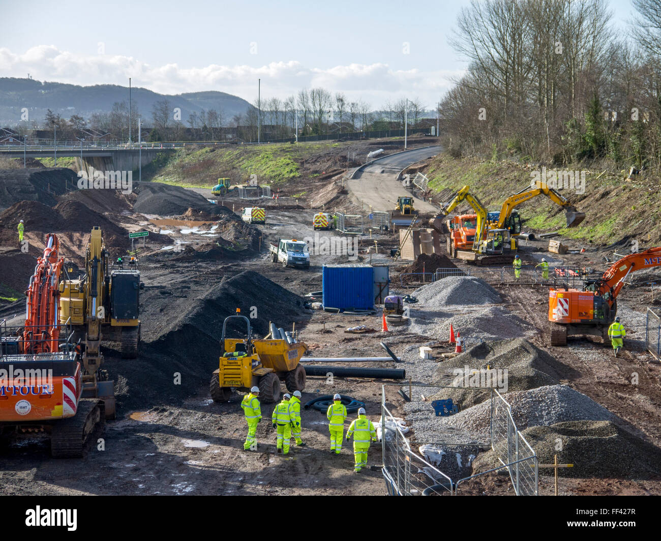 New road construction site, showing men working in safety gear, diggers ...