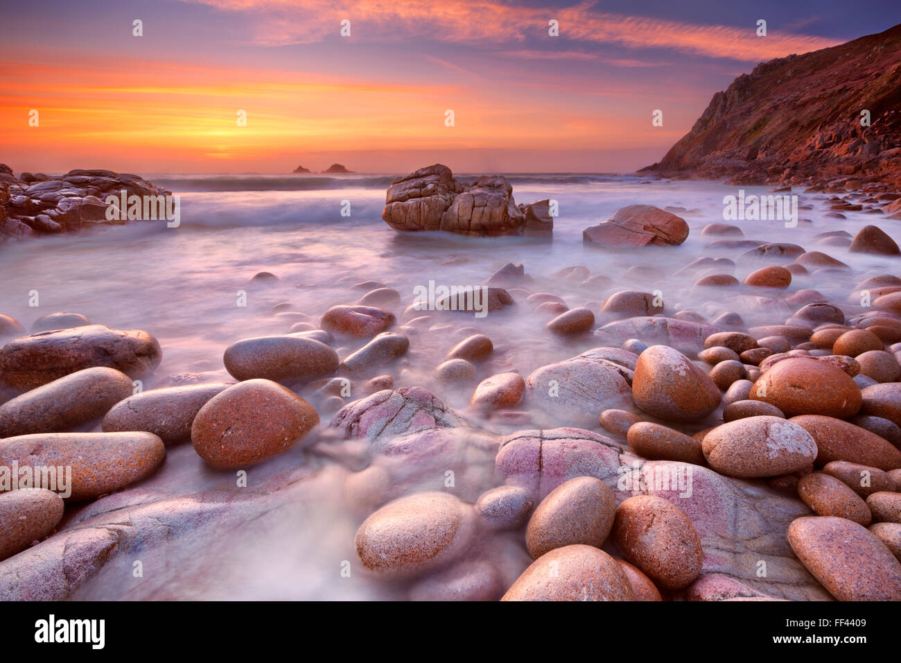 The beautiful rocky beach of Porth Nanven in Cornwall, England at sunset. Stock Photo