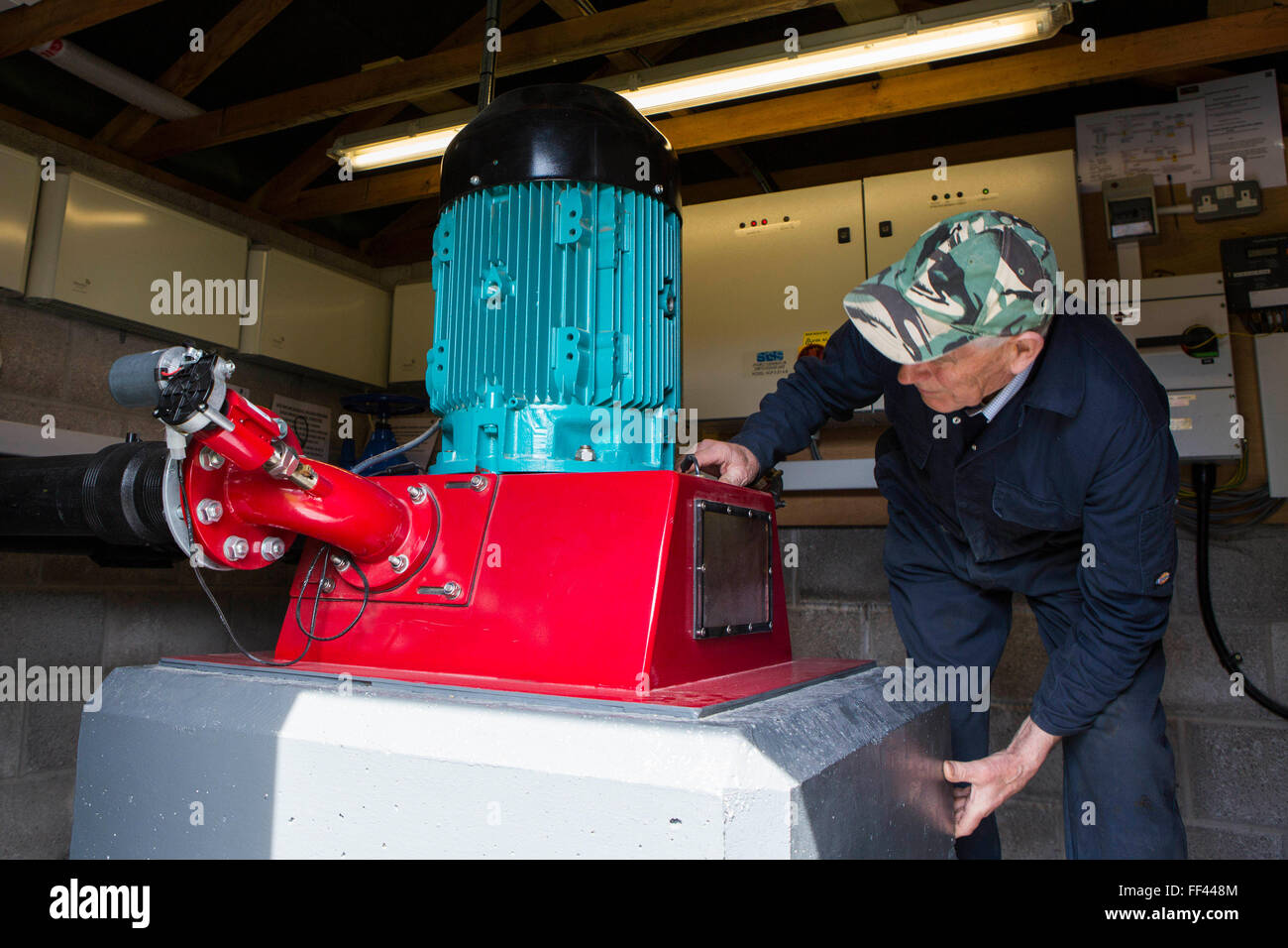 Farmer Howell Williams checking in on his 15kW micro hydro power generator producing electricity at Abercrave Farm on the Brecon Beacons, Wales. Stock Photo