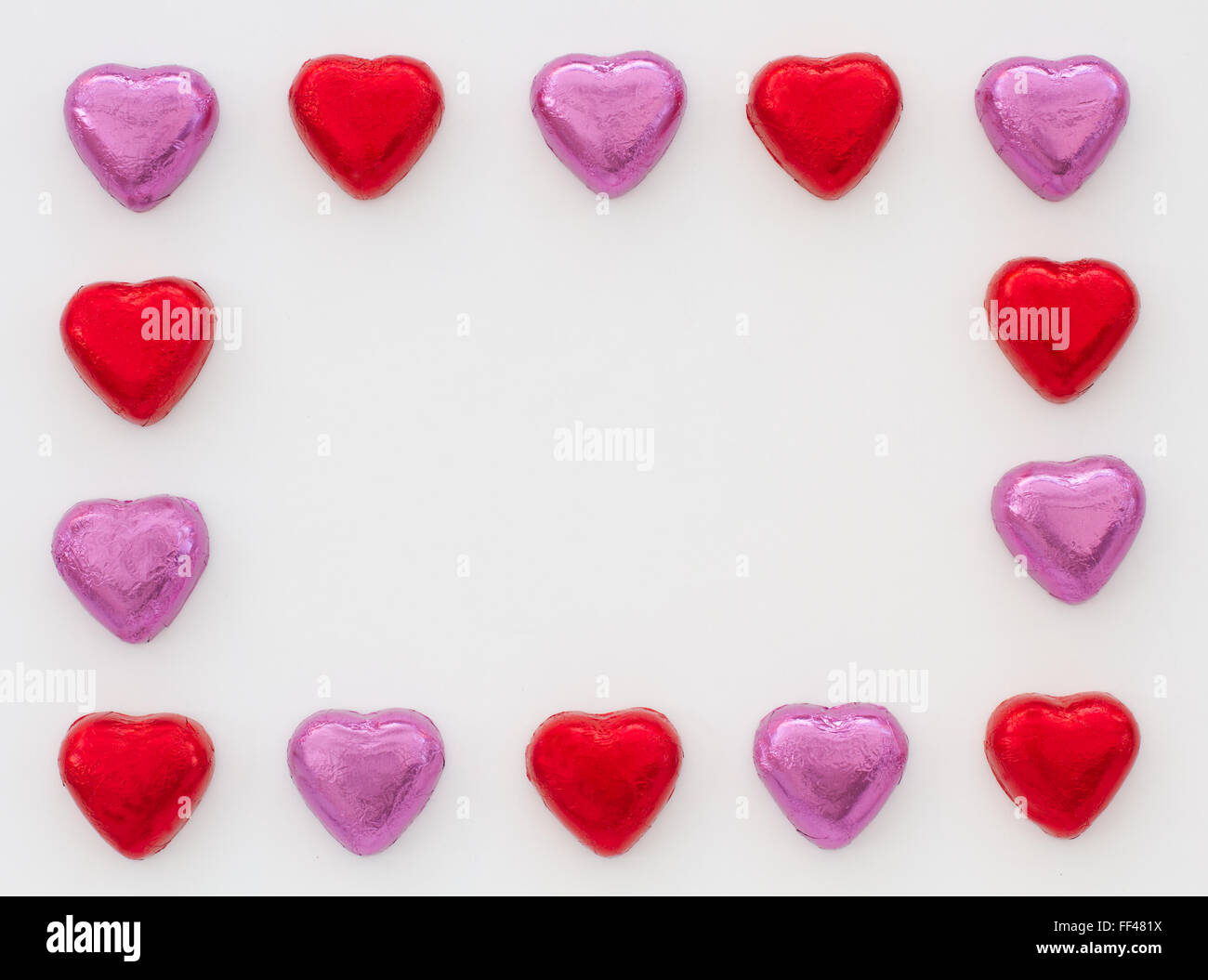 Chocolate heart shapes making a frame around the edge of an image on an isolated white background. Heart shaped candy frame. Stock Photo