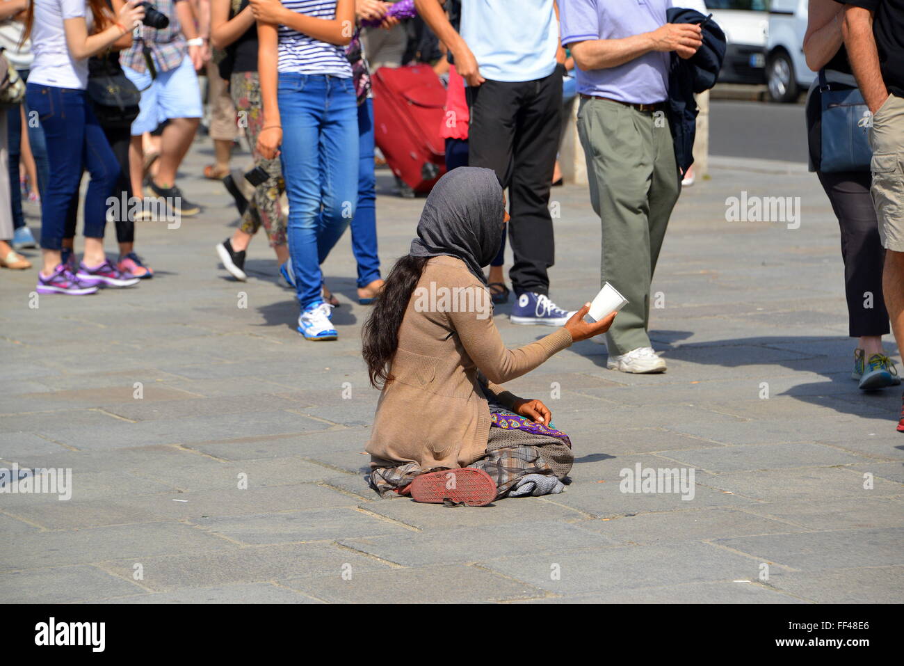 Female gypsy beggar located outside Notre Dam, Paris Stock Photo