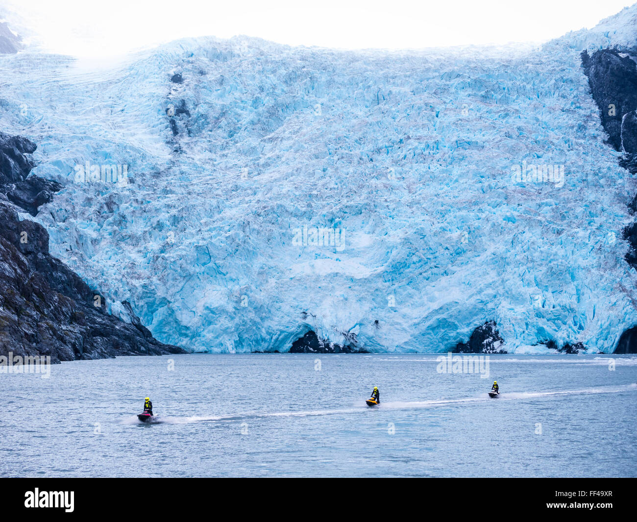 jet-skiers in icecold water in front of glacier of Prince-William-Sound, Alaska. Stock Photo