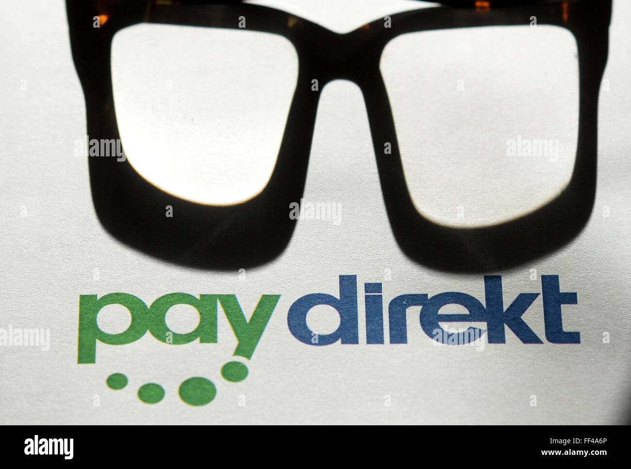 ILLUSTRATION - The logo of the online payment service Paydirekt photographed next to a pair of glasses in Berlin, Germany, 03 February 2016. Paydirekt is a German company with a strict data protection policy that will not reroute funds to intermediary payment service providers. Payment transactions are included in regular account statements. Photo: JENS KALAENE/dpa Stock Photo