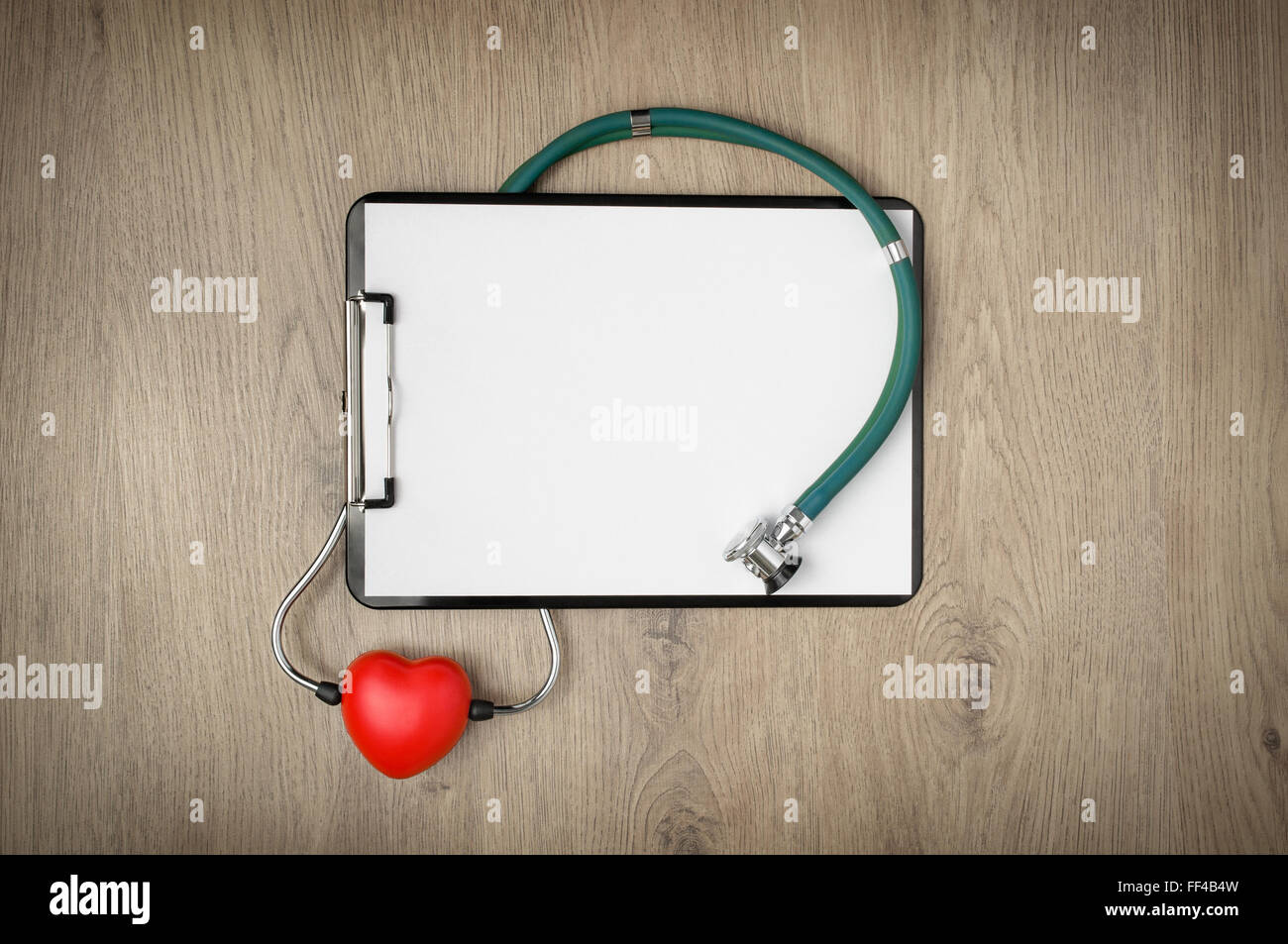 Clipboard with blank white paper, stethoscope and heart shape on wooden ...