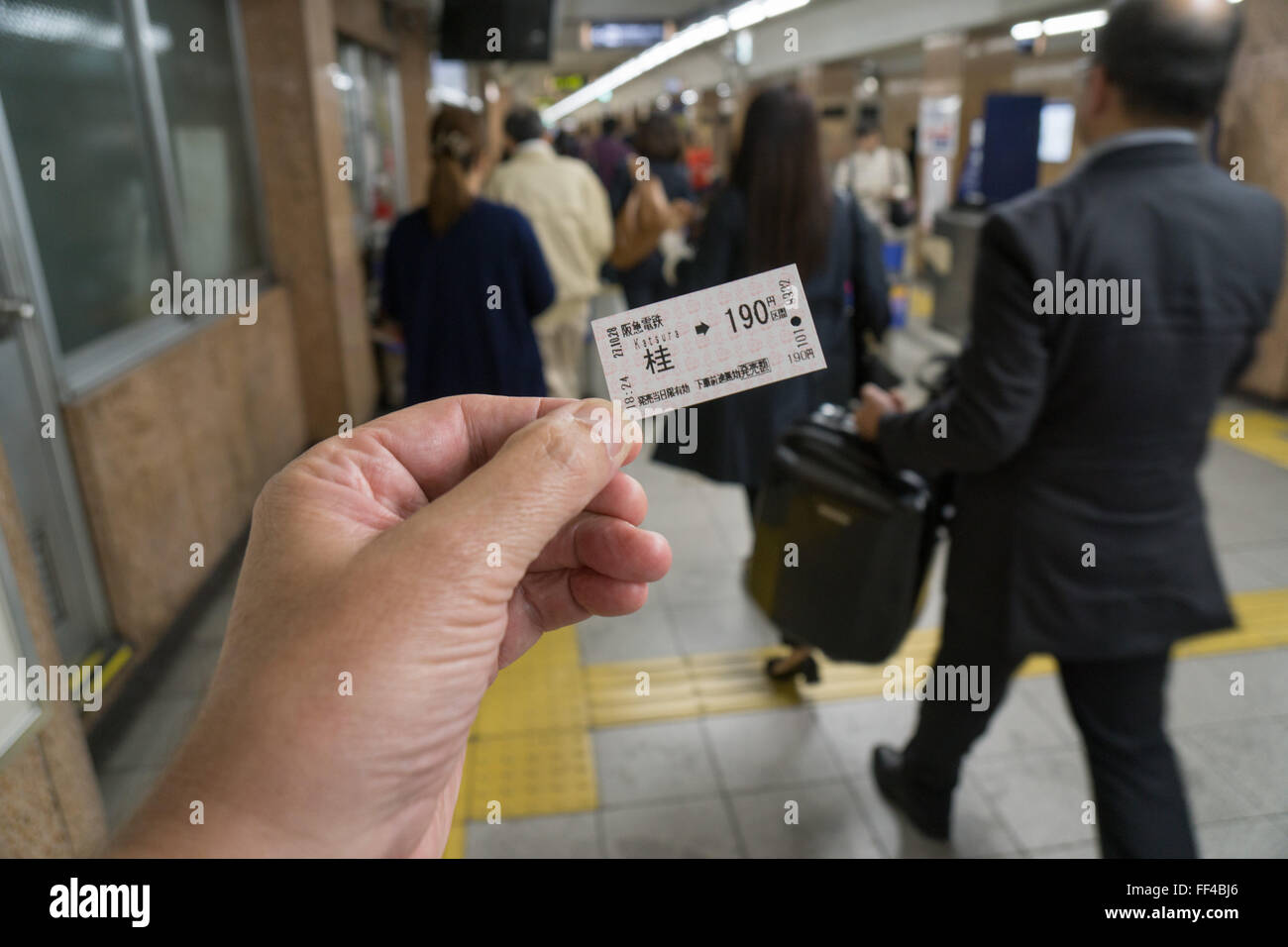 photogarpher holding at subway ticket at at train station in Kyoto Japan Stock Photo