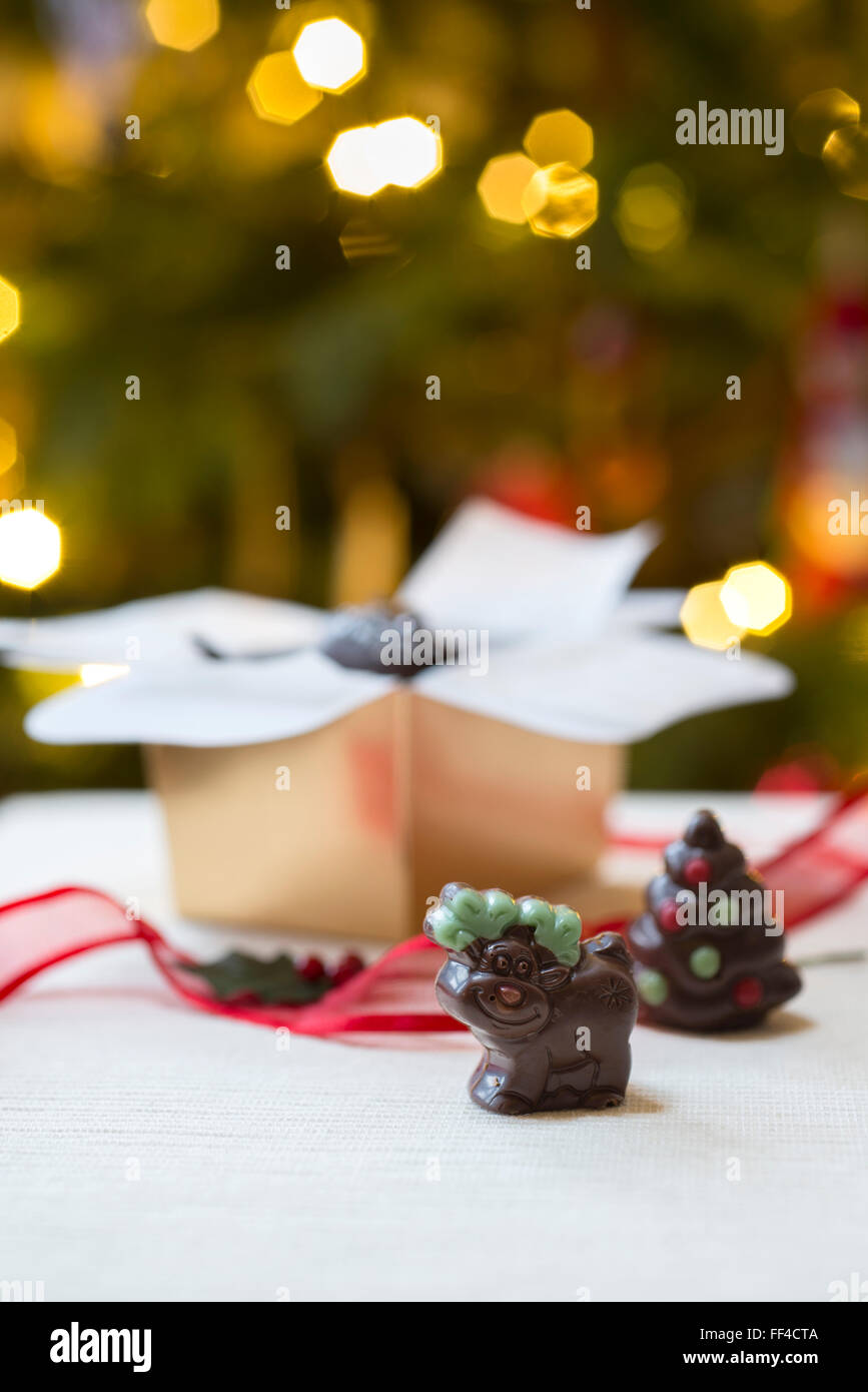 Novelty handmade Christmas chocolates, including a reindeer against the backdrop of Christmas tree lights. Stock Photo