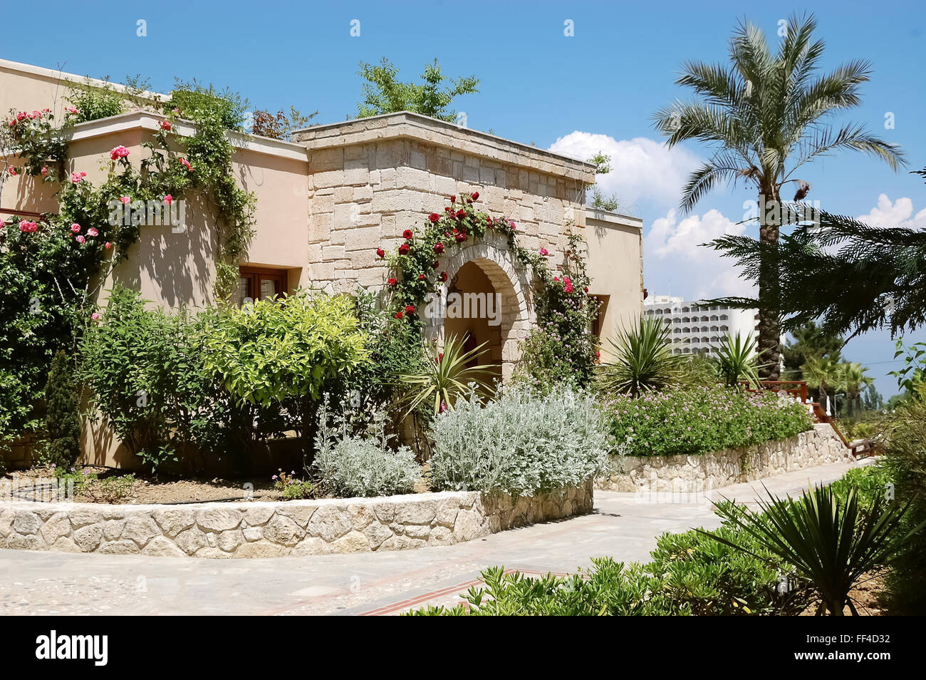 Building with arched entrance and roses in Greek luxury hotel. Stock Photo