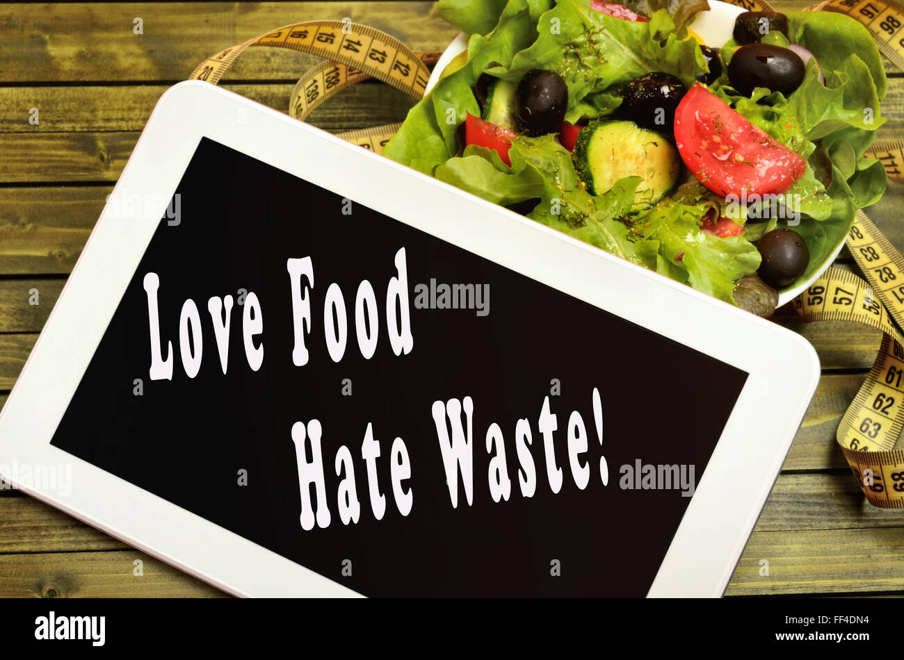 Love food Hate waste written on digital tablet Stock Photo