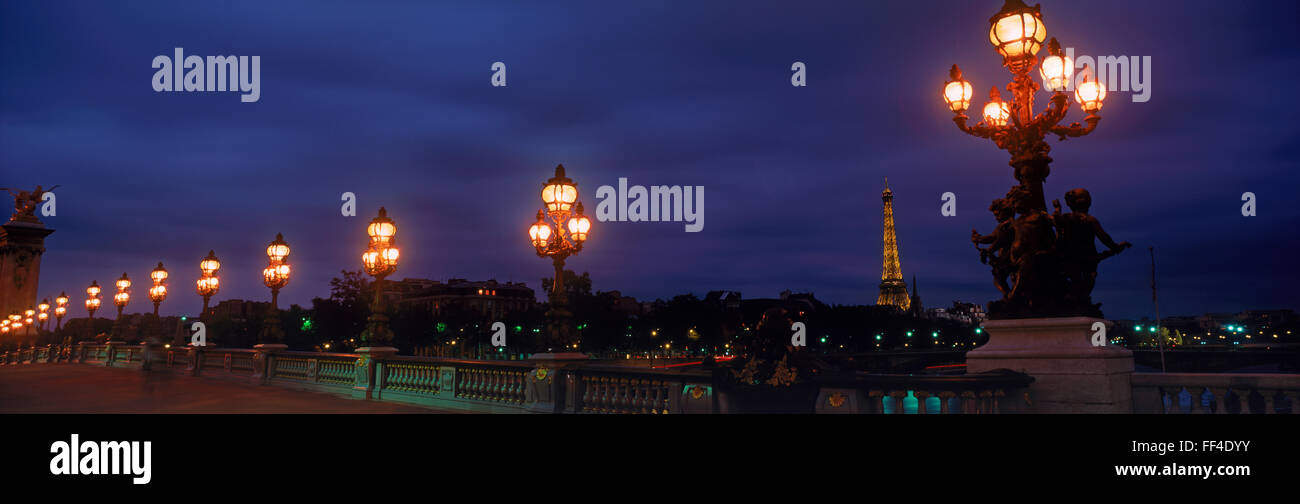 Romantic lamp lights at night in Paris across Pont Alexandre III with Eiffel Tower, Stock Photo