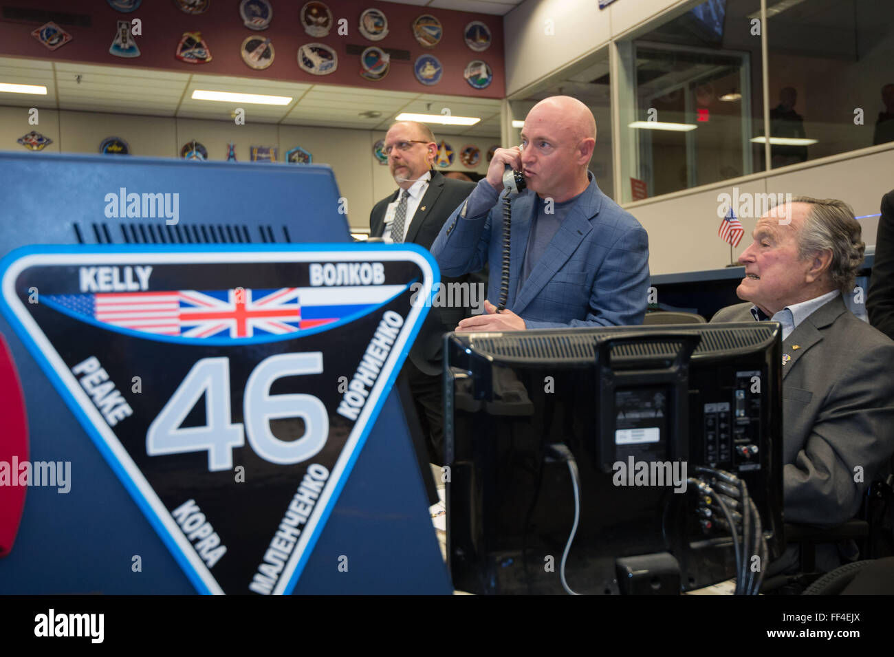 Former President George H.W. Bush, right, with former astronaut Mark Kelly as they speak with twin brother Expedition 46 Commander Scott Kelly and Flight Engineer Tim Kopra currently on the International Space Station from the Flight Control Room during a visit to the Johnson Space Center February 5, 2016 in Houston, Texas. Stock Photo
