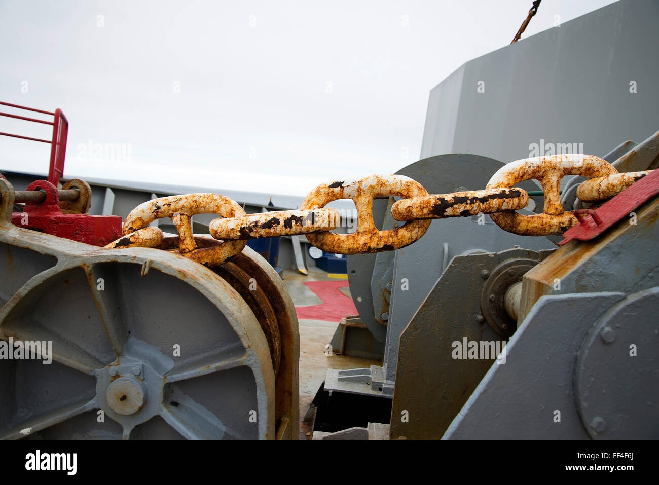 Closeup of huge rusting anchor chain on deck of Container Ship