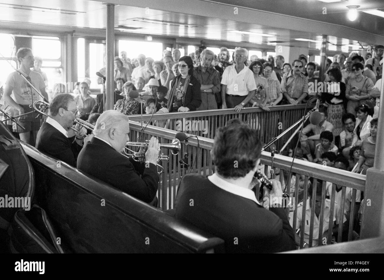 Wild Bill Davison, cornet player, at a concert given as part of the 1982 Kool Jazz Festival. This event was “Jazz on the Hudson” and took place on a boat circling Manhattan. Davison is seated at center, with white hair. Stock Photo