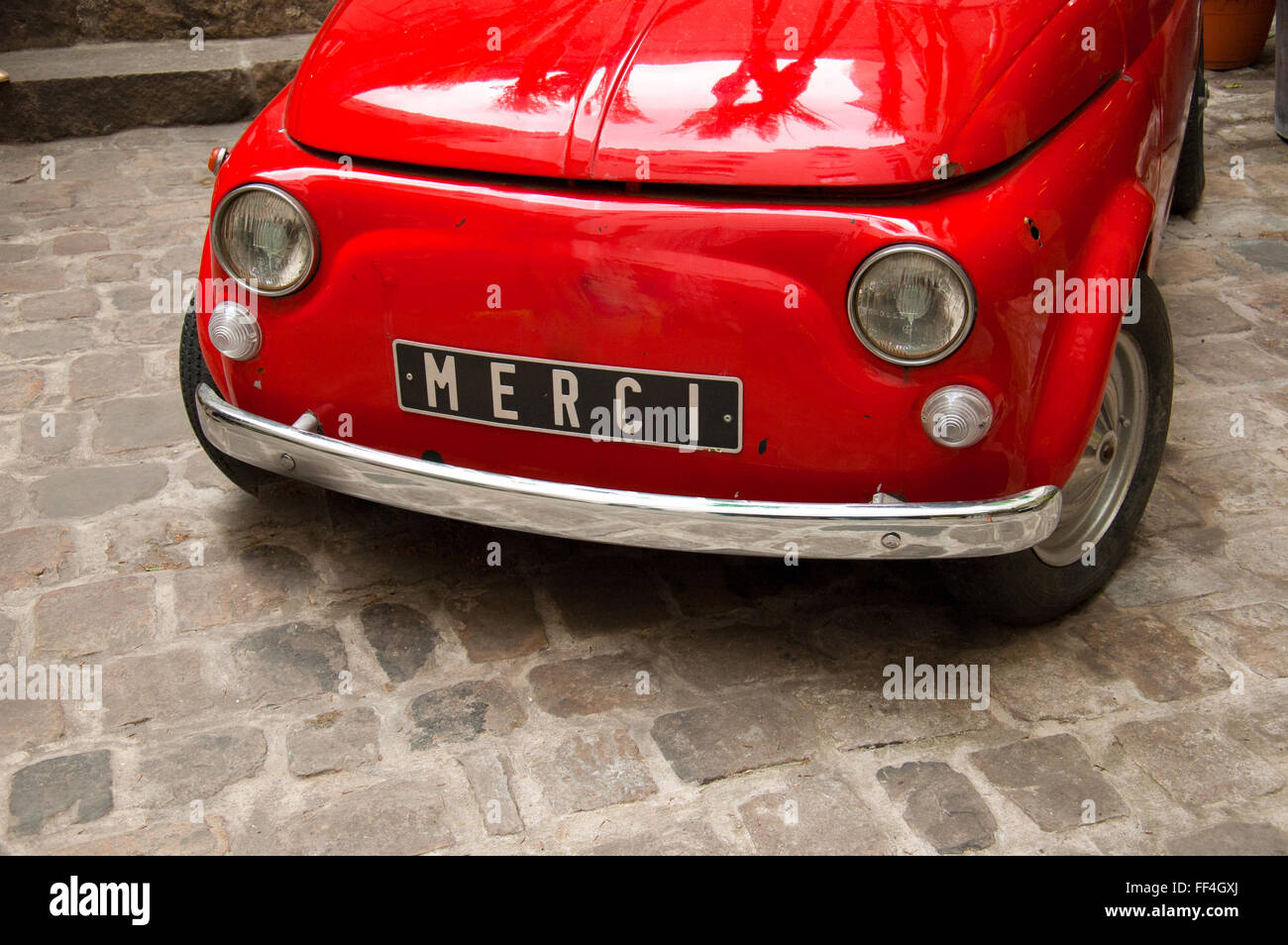Old vintage Italian car in red with Merci written on the plate Stock Photo