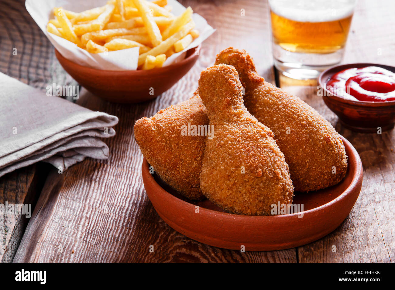 fried chicken leg in breadcrumbs and french fries Stock Photo